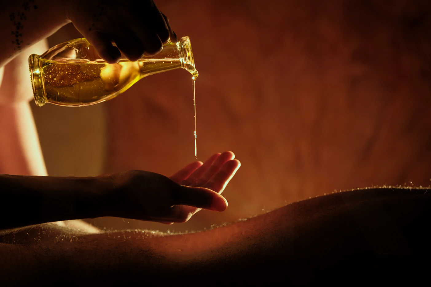 Huile de massage versée au creux de la main, rituel du Massage Voyage à Lyon